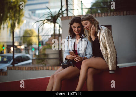 Happy friends using mobile phone Stock Photo