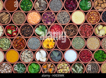 Cooking ingredients. Herbs, spices, nuts, seeds and pulses in round  terracotta pots pattern Stock Photo