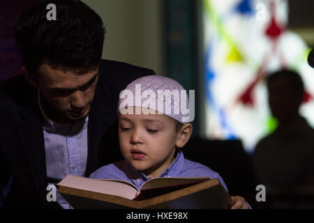 A boy reading the Koran holy book at the annual Koran festival in the Moscow Cathedral Mosque, Russia Stock Photo