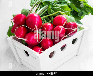 Fresh organic bunch of radishes in wooden crate Stock Photo