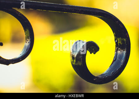 backlit hand made curved wrought iron fence Stock Photo