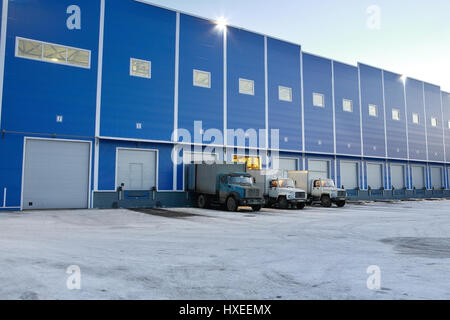 St. Petersburg, Russia - November 21, 2008: Big blue warehouse outside the trucks are unloaded at the loading docks, the evening. Stock Photo