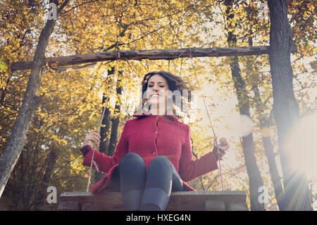 Happy young woman on swing Stock Photo