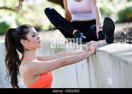 Girls workout and stretch together in a beautiful outdoor and urban setting. Stock Photo