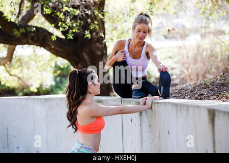 Girls workout and stretch together in a beautiful outdoor and urban setting. Stock Photo