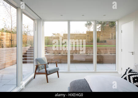 View of bedroom looking out to garden. Private Houses Withdean Road, Brighton, United Kingdom. Architect: John Pardey Architects, 2017. Stock Photo