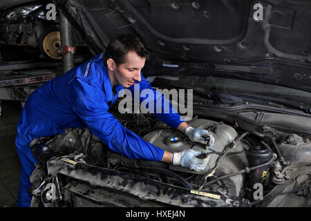 Saint Petersburg, Russia - June 26, 2014: Saint Petersburg, Russia - June 26, 2014: Service station workers opened the hood and check the  car electri Stock Photo