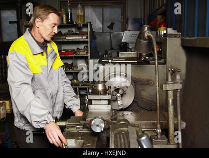 St. Petersburg, Russia - 22 December 2011: Turner grinds steel part on a lathe. Stock Photo