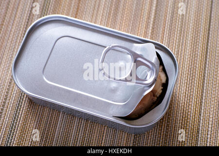 Open tin can with cod liver on bamboo napkin. Stock Photo