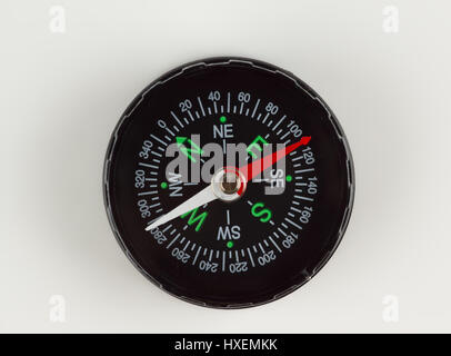 round magnetic compass with bright symbols lies on the table Stock Photo