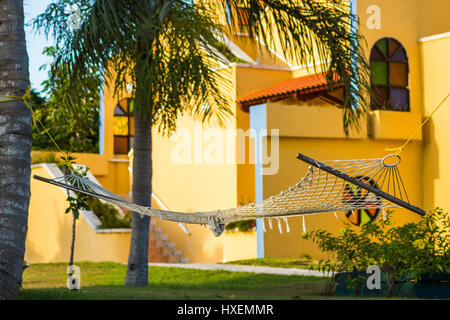 A hammock tied between two trees in a pretty garden in Cuba. Stock Photo