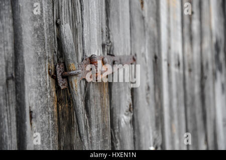 A rusted latch on an old wooden shed door Stock Photo