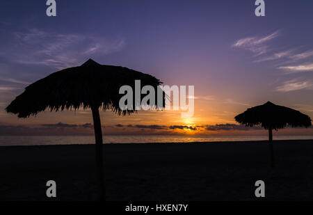 Beach parasols seen on the coast of Cayo Coco at sunrise. Stock Photo