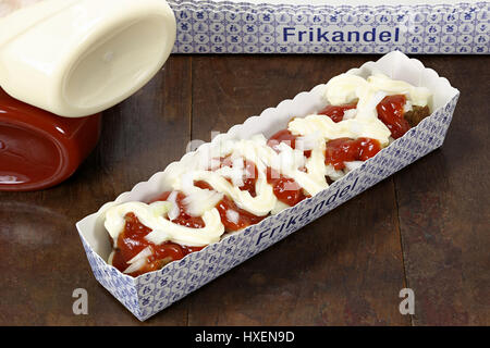 traditional Dutch frikandel special in a cardboard container on wooden background Stock Photo