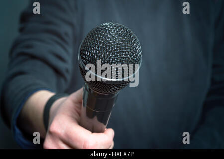 Journalist making speech with microphone and hand gesturing concept for interview. Selective focus. Stock Photo