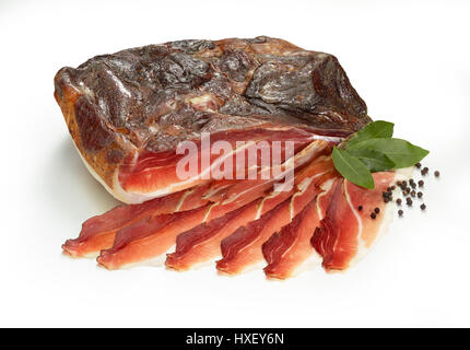 South Tyrolean ham with bay leaves (Laurus nobilis) and peppercorns (Piper) as decoration Stock Photo