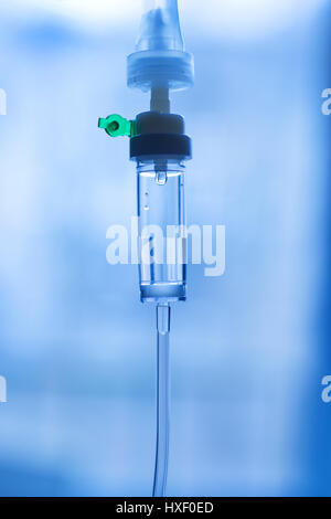 Part of disposable infusion set close up. On abstract blue background. Treatment, medication and hospital theme Stock Photo