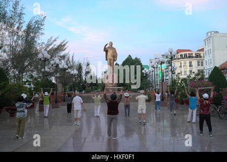 A group of people doing morning exercises in front of the Ho Chi Minh statue in Can Tho, Vietnam. Stock Photo