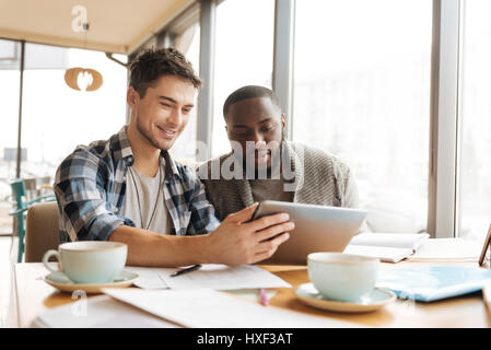 Positive students resting in the cafe together Stock Photo
