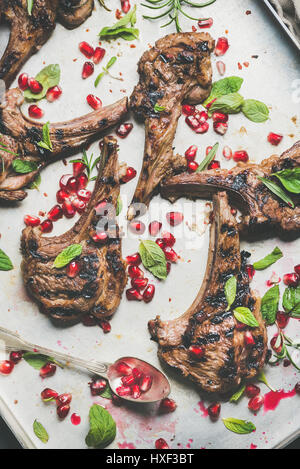 Lamb meat ribs barbecue with pomegranate seeds and herbs Stock Photo