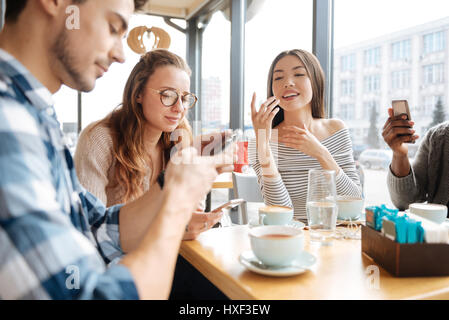 Friends using smartphones in the cafe Stock Photo