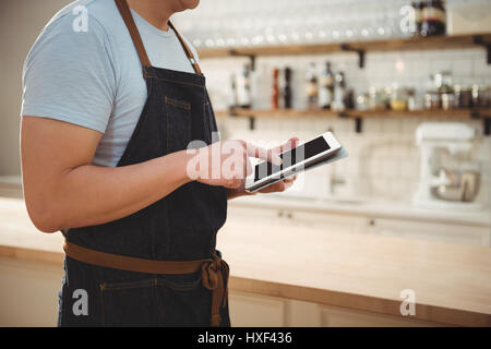 Midsection of male chef using digital tablet in commercial kitchen Stock Photo