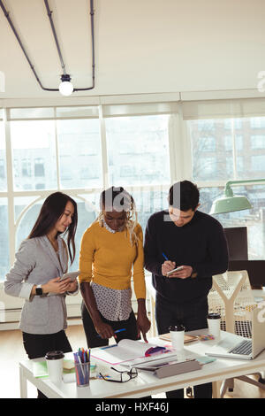 Group of executives working together at desk in office Stock Photo