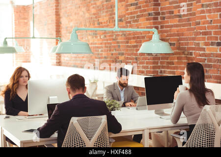 Group of executives working together at desk in office Stock Photo