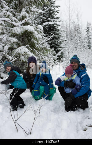 Portrait of happy parents and children enjoying in snow Stock Photo