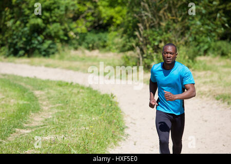 Active african american man running on path outdoors Stock Photo