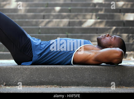 Side portrait of a young man resting outside. Lying on back Stock Photo