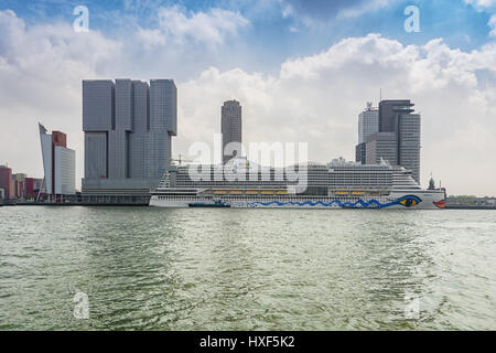Rotterdam, Netherlands – August 18, 2016: For the building The Rotterdam the cruise ship AIDA has docked along the Wilhelminakade in Rotterdam harbor Stock Photo
