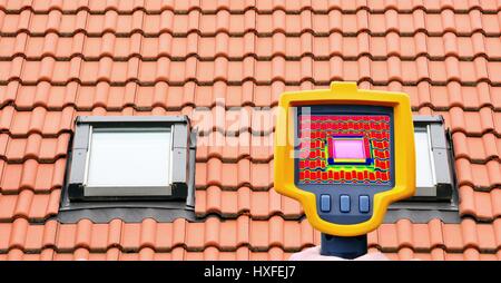 An infrared thermal imager showing roof window heat loss. Stock Photo