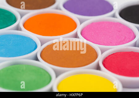 low angle closeup of water color palette in white plastic containers selective focus Stock Photo