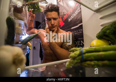 Athlete is checking out the content of the fridge Stock Photo