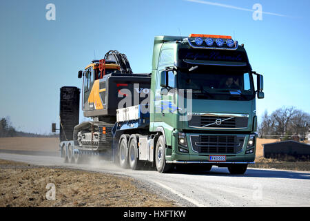 SALO, FINLAND - MARCH 19, 2017: Green Volvo FH16 of Kuljetus Nurmela transports Volvo EC300E Crawler excavator on gooseneck trailer along highway on a Stock Photo