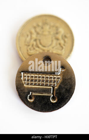 One pound coin and a same sized supermarket trolley token. A new UK  £1 coin was introduced on 28 March 2017 with the old one pound being phased out. Stock Photo