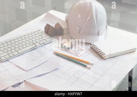 Engineer or architect Office desk background construction project ideas concept, With drawing equipment, double exposure with crane and building under Stock Photo