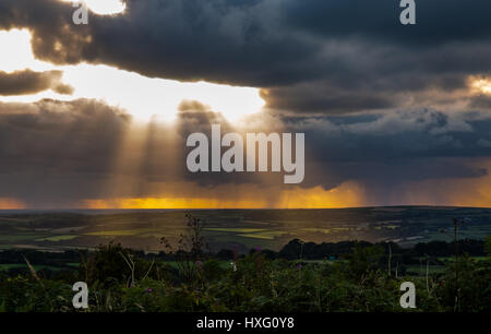 Just before sunset. Light rays shining through the stormy clouds and hitting Bodmin Moor, Cornwall, down below. Stock Photo