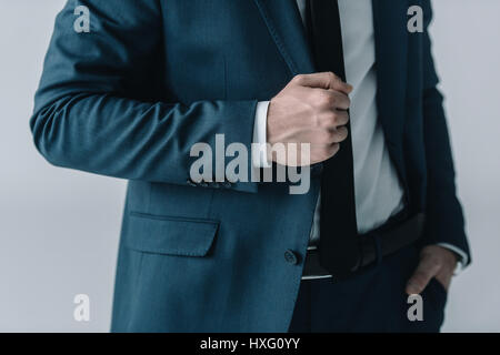 Mid section of businessman in stylish suit posing on grey Stock Photo