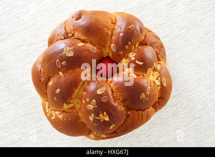 Traditional Easter bread ,tsoureki with red egg in the middle on white wooden background Stock Photo