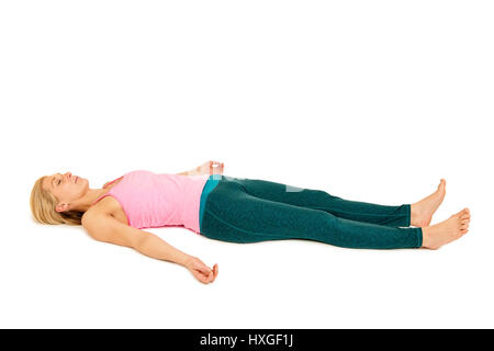Flat angular body side view of an on the back of the young woman in the Yoga position 'Dead position' (shavasana) on a white background. Stock Photo