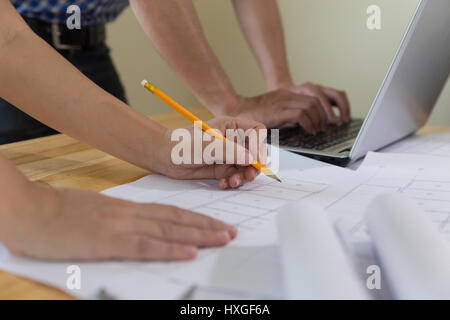 engineer meeting for architectural project, working with partner and engineering tools at workplace. Architect working on blueprint and laptop. Constr Stock Photo
