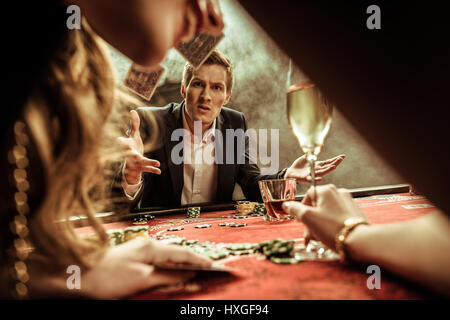 angry man throwing cards while playing poker Stock Photo