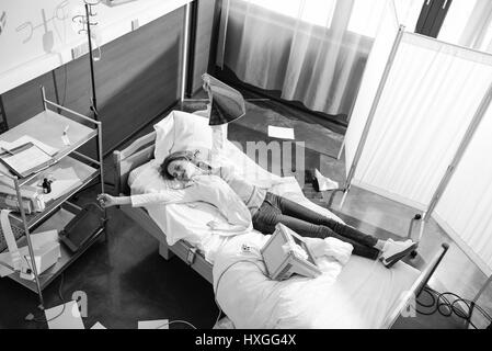 high angle view of doctor with x-ray picture lying on hospital bed, black and white photo Stock Photo