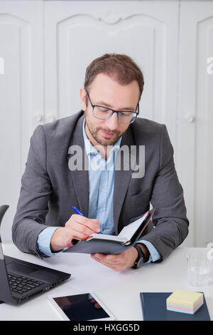 Businessman taking notes at his desk Stock Photo