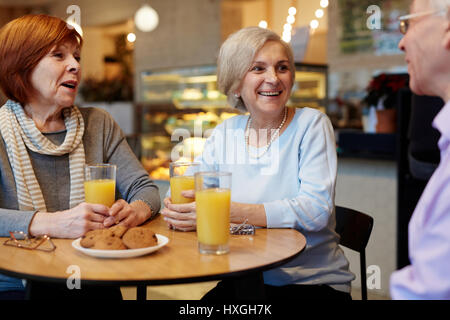 Old buddies sitting by table in cafe and having talk Stock Photo