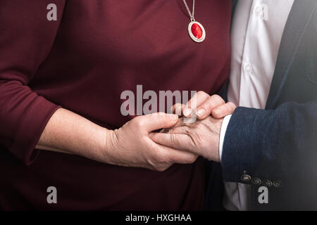 Close-up partial view of senior couple holding hands Stock Photo