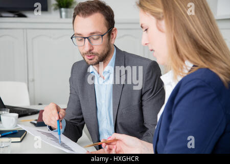 Male and female business colleagues discussing about business chart Stock Photo