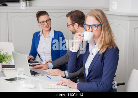 Portrait of a young businesswoman drinking coffee during the meeting Stock Photo